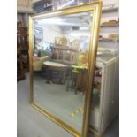 A large modern gold painted mirror 122 x 155cm
