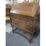 A 1930's oak bureau standing on barley twist legs