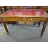A mahogany writing table having two drawers and a burgundy coloured leather scriber on castors 74