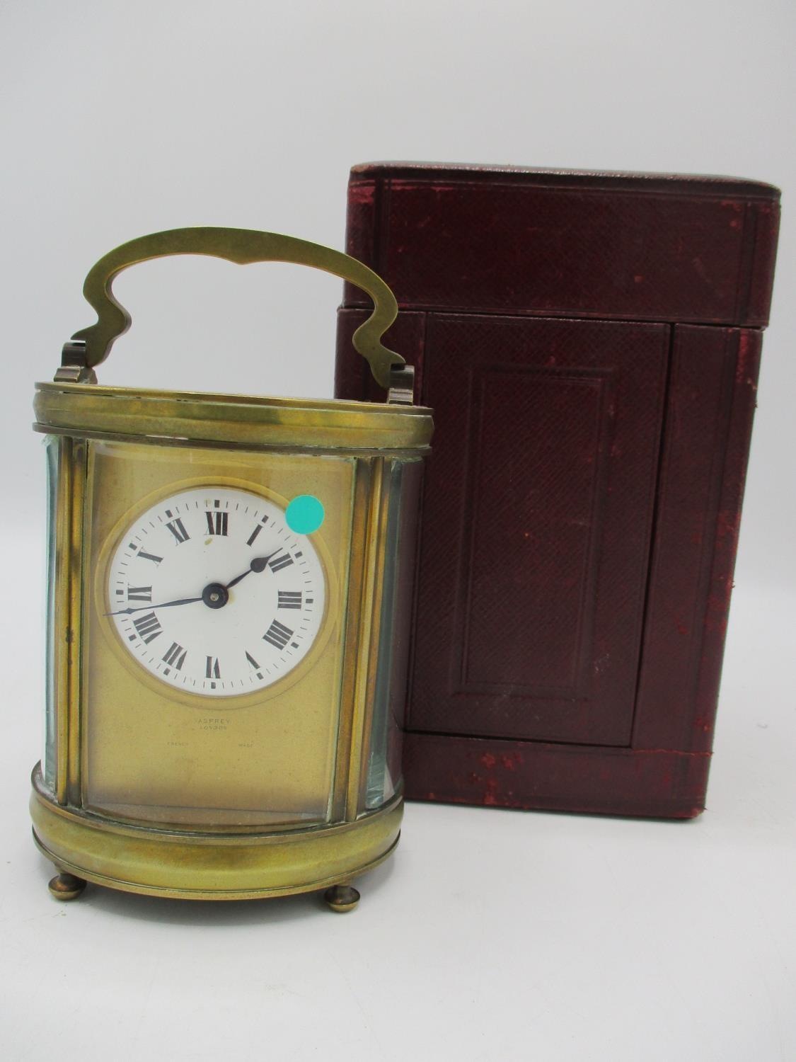 A late 19th/early 20th century French gilt metal carriage clock with leather fitted travel case. The