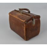 A doctor's brown leather gladstone bag with label for John Warrillow, Birmingham, containing medical