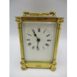 A late 19th century brass cased carriage clock having a white enamel dial with Roman numerals, the