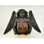 A 19th century Continental religious carving of an angel holding a red painted shield with carved
