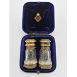 A cased Victorian silver gilt double ended 'binocular' scent bottle and combined vinaigrette by