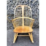 An Ercol blonde elm chairmakers rocking chair, with spindle back, blue label to the back of the
