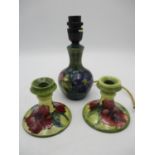 A pair of Moorcroft dwarf candlesticks, in the Hibiscus pattern on green ground, impressed backstamp