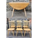 A 1960s Ercol model 384 dining table and chairs, the table of oval form with drop leaf and