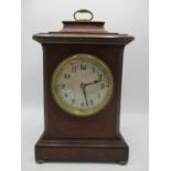 An Edwardian walnut mantle clock having a silvered dial with Arabic numerals, the movement
