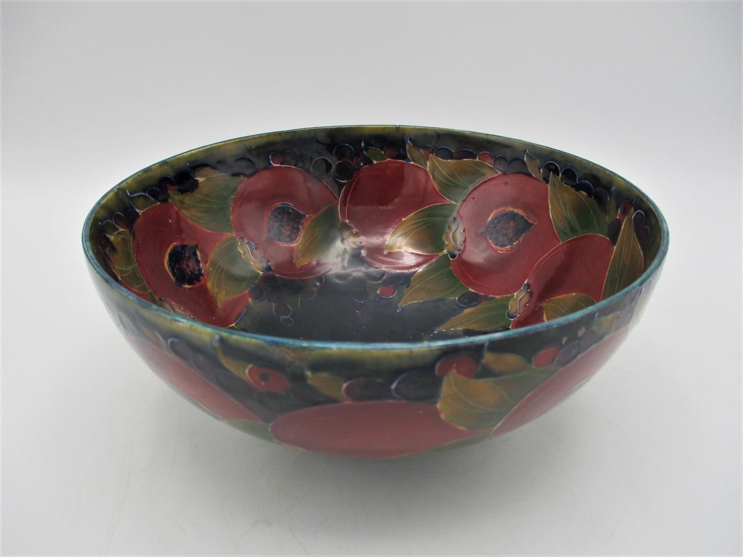 A large William Moorcroft bowl in the pomegranate pattern, raised on a small circular base, with