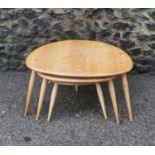 A nest of three 'pebble' Ercol tables, beech and elm, each raised on three turned splayed tapered