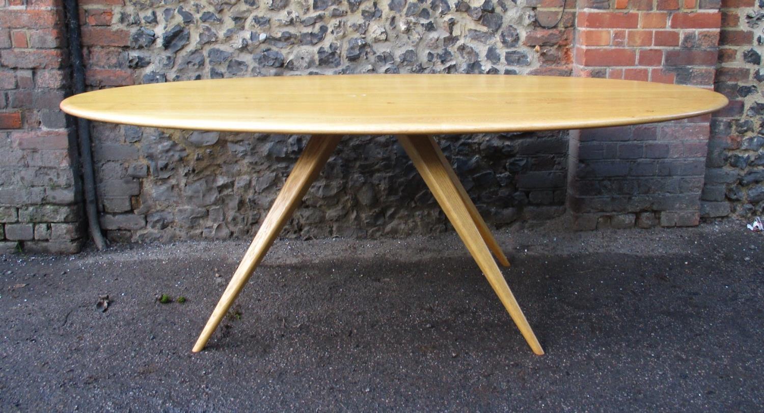 A Modern Design light oak dining table by Benchmark Furniture, of oblong form supported on four