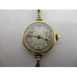 An early 20th century Longines 18ct gold ladies manual wind wristwatch on a 9ct gold strap. The dial