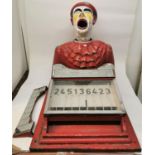 A vintage fairground funfair laughing clown head ball game, painted in red and yellow, with score
