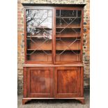 A George III mahogany bookcase cabinet with a moulded cornice, over a pair of astragal glazed doors,