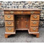 A mid 18th century string inlaid walnut kneehole desk with a crossbanded top, over a long drawer and