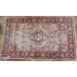 A hand woven Persian Isfahan silk rug, with central medallion on navy ground, burnt red spandrels