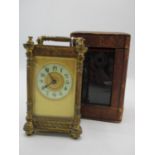 A late 19th century brass cased carriage clock with a fitted leather travel case. The enamel dial
