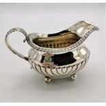 A George III silver milk jug by Joseph Angell I, London 1816, with part fluted body, gadrooned