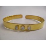 A silver gilt bangle set with three diamonds Location: CAB