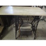 A Singer treadle table with a marble top 74 h x 91cm w