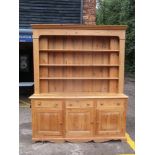 A late 20th century pine dresser with three shelves over three inline drawers and three doors 120