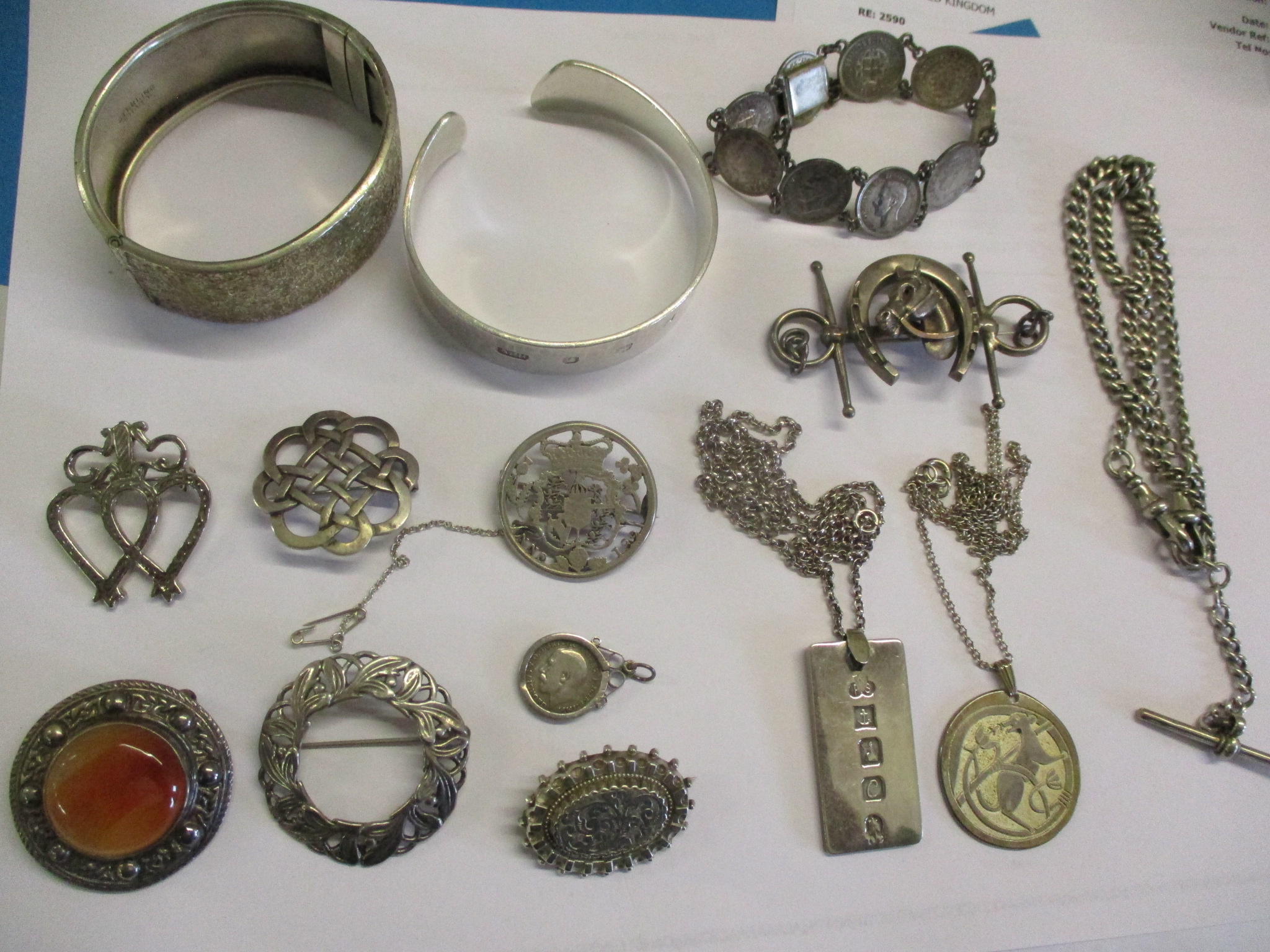 A silver fob watch chain, a silver ingot pendant on a white metal chain, two silver bangles and