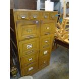 An early to mid 20th century light oak filing cabinet with four small above eight larger drawers