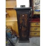 A 19th century Japanned cupboard, the door decorated with figures leaning our of a building others