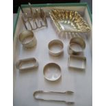 A small collection of silver to include a bon bon dish, toast rack, sugar tongs and six napkin