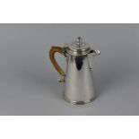 An early 20th century silver hot water jug by Walter H Wilson Ltd, London 1933, of cylindrical,