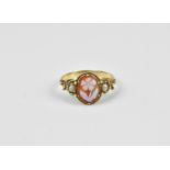 A Georgian yellow metal carnelian cameo ring depicting a flower flanked with seed pearls, size I 1/2