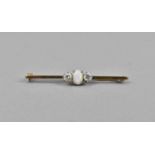 A 9ct gold opal and sapphire bar brooch, the central cabochon opal flanked with white sapphires