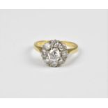 An 18ct gold and diamond floral cluster ring, with central round cut diamond with a surround of