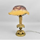 An early 20th century Daum glass mushroom lamp, the mottled red and yellow domed shade with lobed