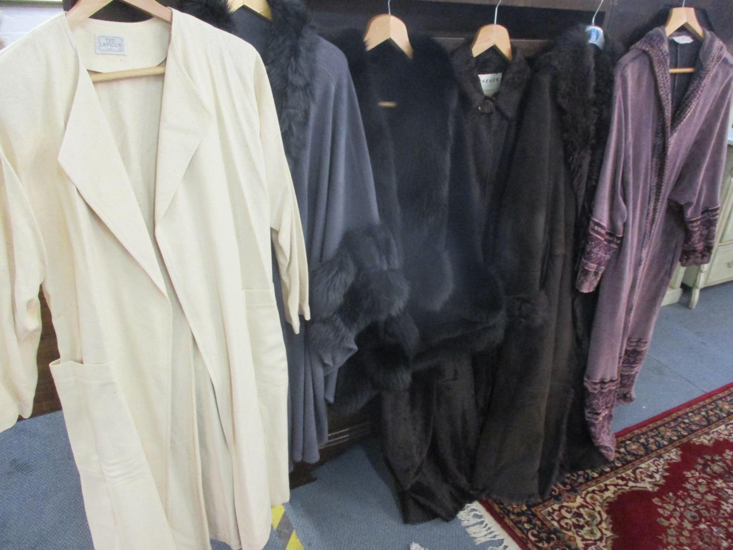 A quantity of ladies outdoor overgarments comprising modern capes with faux fur trim, a brown