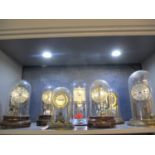 A group of seven anniversary clocks under plastic and glass domes to include Pinchin Johnson, a