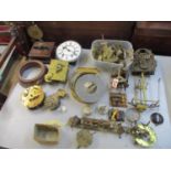 A box of various clock parts to include movements, wheels, dials and early electric clock parts
