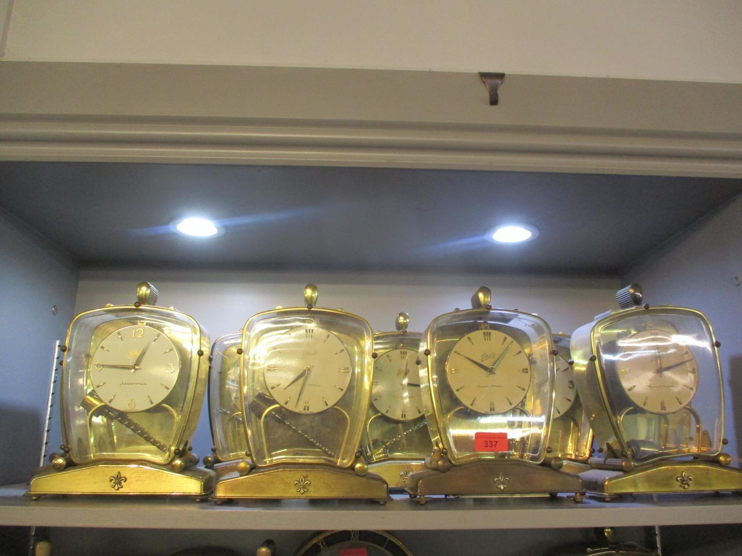 Eight 20th century Schatz mantle clocks in glass cased with fleur de lis emblem to the stand A/F