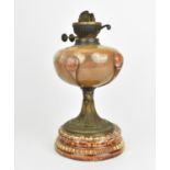 A 19th century Arts and Crafts style oil lamp, with bulbous glass body on a spreading metal pedestal