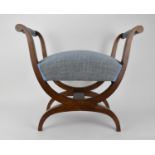 A 19th century Biedermeier upholstered walnut window seat or curule stool, with new blue fabric