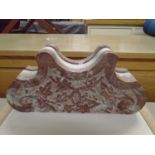 A carved white and variegated marble clock holder