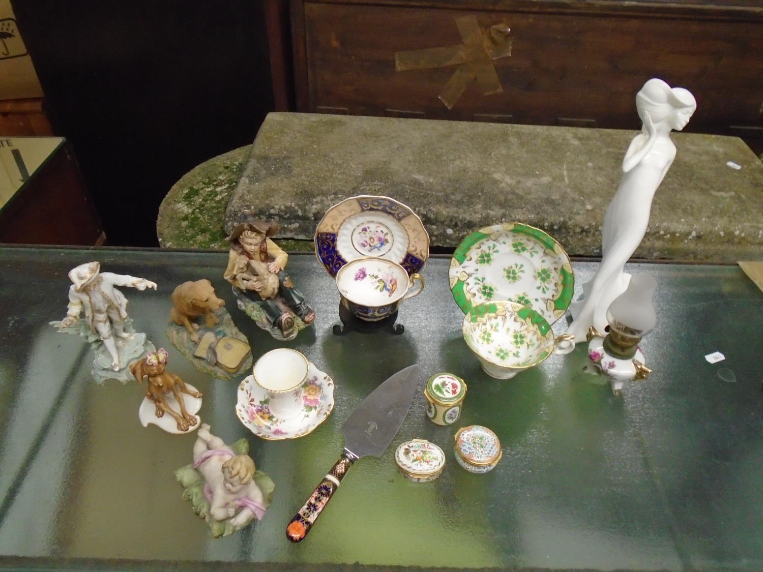 A selection of ornaments to include two 19th century cups and saucers, a Crown Derby handled cake