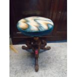 A Victorian mahogany music stool with circular upholstered swivel seat on carved pedestal base