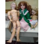 A Schoenau and Hoffmeister bisque headed girl doll, with sleep eyes, open mouth showing three teeth,