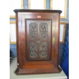 An early 20th century mahogany corner wall cupboard having a single carved door with the date 1906