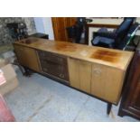 A retro G-Plan teak sideboard with three central drawers flanked by cupboard doors on tapering