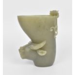 A Chinese 20th century carved celadon jade libation cup, modelled with a kylin and water buffalo,