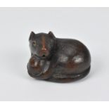 A Japanese carved wood netsuke, 19th century, modelled as a rat holding a nut, its tail coiled