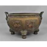 A Chinese cast bronze twin handled jardinière pot, of octagonal form with bulbous body, each faceted