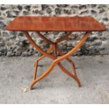 A 19th century mahogany folding campaign or coaching table, raised on scissor action shaped x-